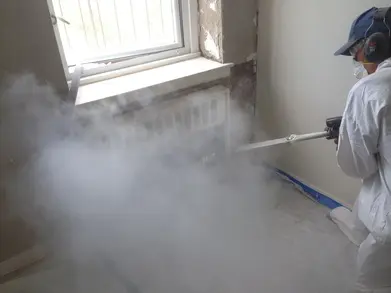 A steam cleaner is spraying water onto the floor.